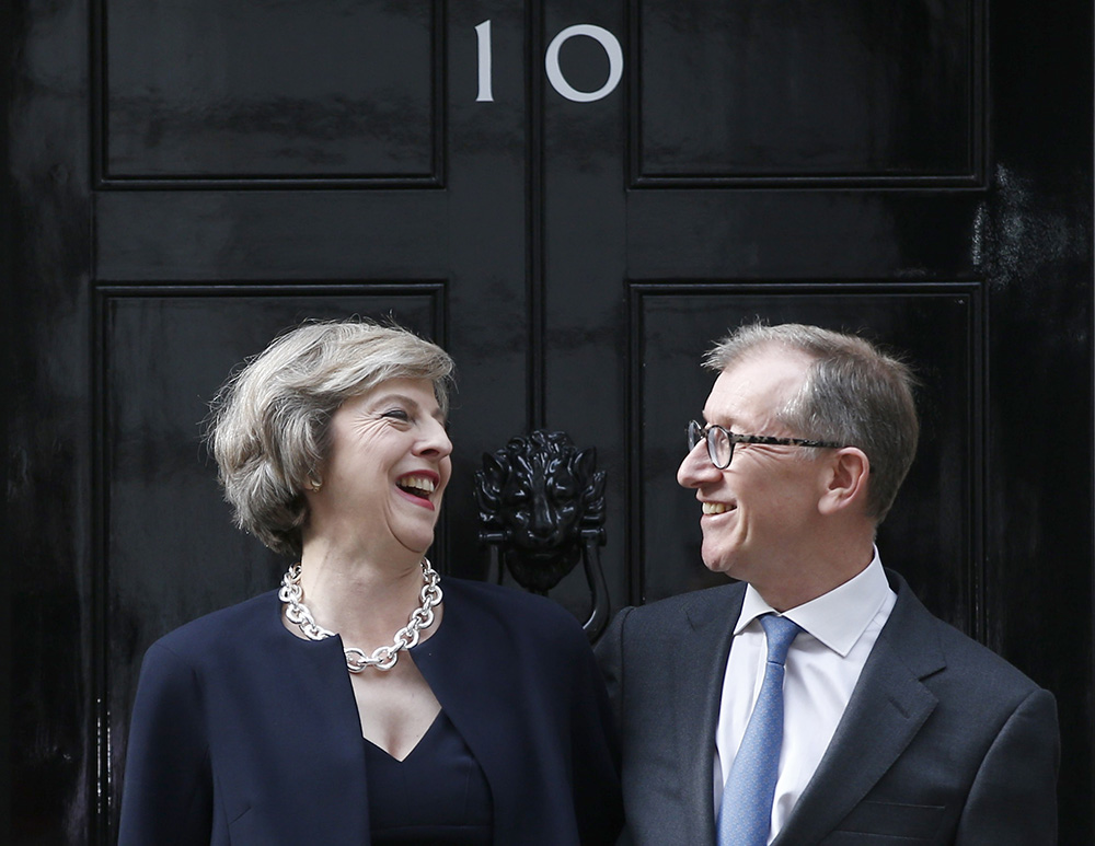 Theresa May and husband Philip pose for the media outside number 10 Downing St., in central London, Wednesday. May was expected to begin appointing new Cabinet ministers as early as Wednesday evening — including a "Brexit" minister to oversee talks on a British EU exit from the 28-nation EU. 