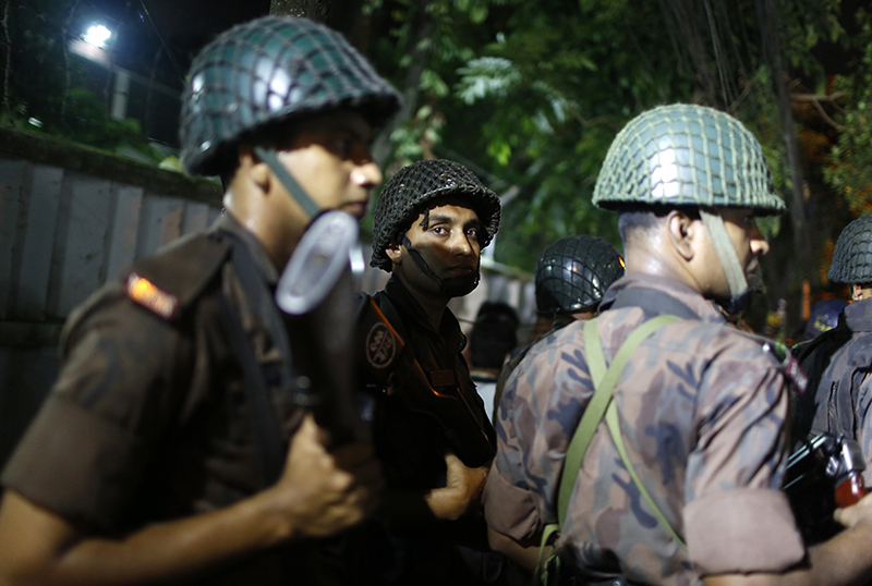 Bangladeshi security personnel stand guard near the Holey Artisan Bakery restaurant in Dhaka.