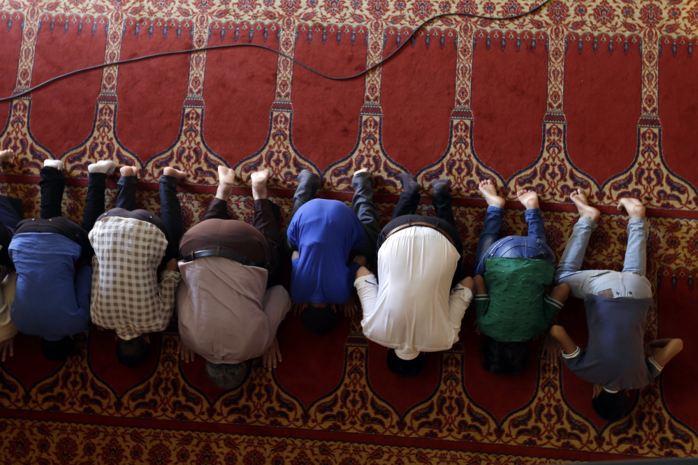 Muslim migrants who live in Greece pray at the Greek-Arab Cultural Center, a Muslim prayer site, in Athens, Thursday, Aug. 4, 2016. Lawmakers in Greece have approved construction of a state-funded mosque near central Athens, a proposal that triggered dissent within the country's coalition government amid a heated public debate on how manage the migrant crisis. (AP Photo/Thanassis Stavrakis)