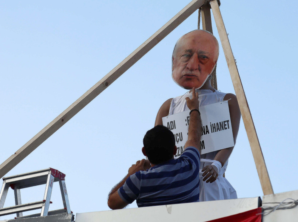 A man attaches an image to create an effigy of Fethullah Gulen – who is accused of being behind the July 15 coup – on a makeshift gallows at in Ankara, Turkey, on July 29.