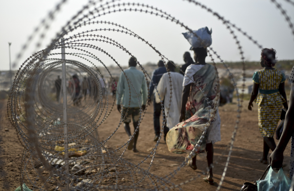 Displaced people walk next to a razor wire fence at the United Nations base in the Juba, South Sudan. The city is also a destination for girls who try to flee being sold into marriage in order to expand their family's cattle herds or to buy wives for their brothers.
Associated Press/Jason Patinkin