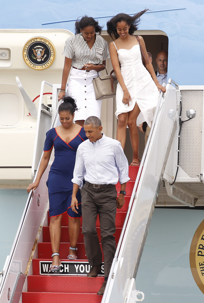 President Obama and first lady Michelle Obama exit Air Force One followed by daughters Sasha, left, and Malia, right, at the Cape Cod Coast Guard Station in Bourne, Mass., on Saturday en route to Martha's Vineyard. (AP Photo/Stew Milne)