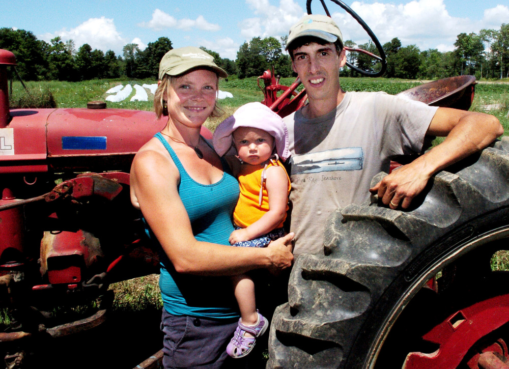 Johanna Burdet and Jarret Haiss, with 18-month-old Tiger, cultivate organic vegetables and make hay at Moodytown Gardens in Palmyra.
David Leaming/Morning Sentinel