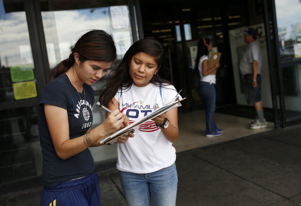 Fabiola Vejar, right, registers Stephanie Cardenas to vote in June in Las Vegas. Shielded from deportation under an Obama administration program that protects those brought to the country illegally as children, Vejar, 18, cannot vote. So she volunteers with Mi Familia Vota, encouraging others to be heard at the ballot box.