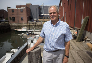 Charlie Poole, president of Proprietors of Union Wharf, says that "without ... proper water depth at all tides, we do not have anything to offer the marine business world." At left, the channel in the central part of the harbor is dredged in 2014.