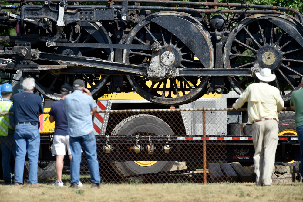 The Old 470 locomotive hangs in the air by two cranes as it is loaded onto a truck Monday to be taken to Ellsworth for a restoration project. The three-day move by the New England Steam Corporation comes after years of fundraising.