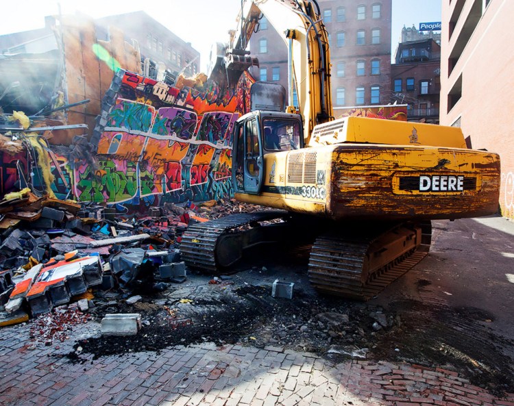Workers demolish the famed graffiti mural at Asylum in Portland on Monday.