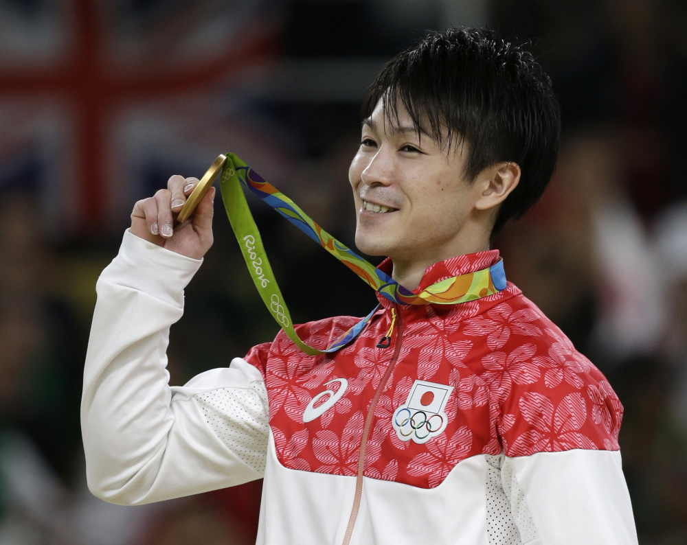 Japan's Kohei Uchimura displays his gold medal Wednesday after winning the artistic gymnastics men's individual all-around final in Rio de Janeiro