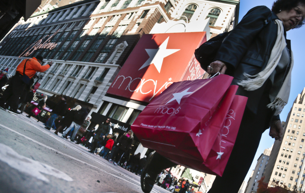 A shopper crosses an intersection with her purchases outside the Macy's store in New York City. According to its website, Macy's employs about 300 workers at its two Maine locations in South Portland and Bangor.