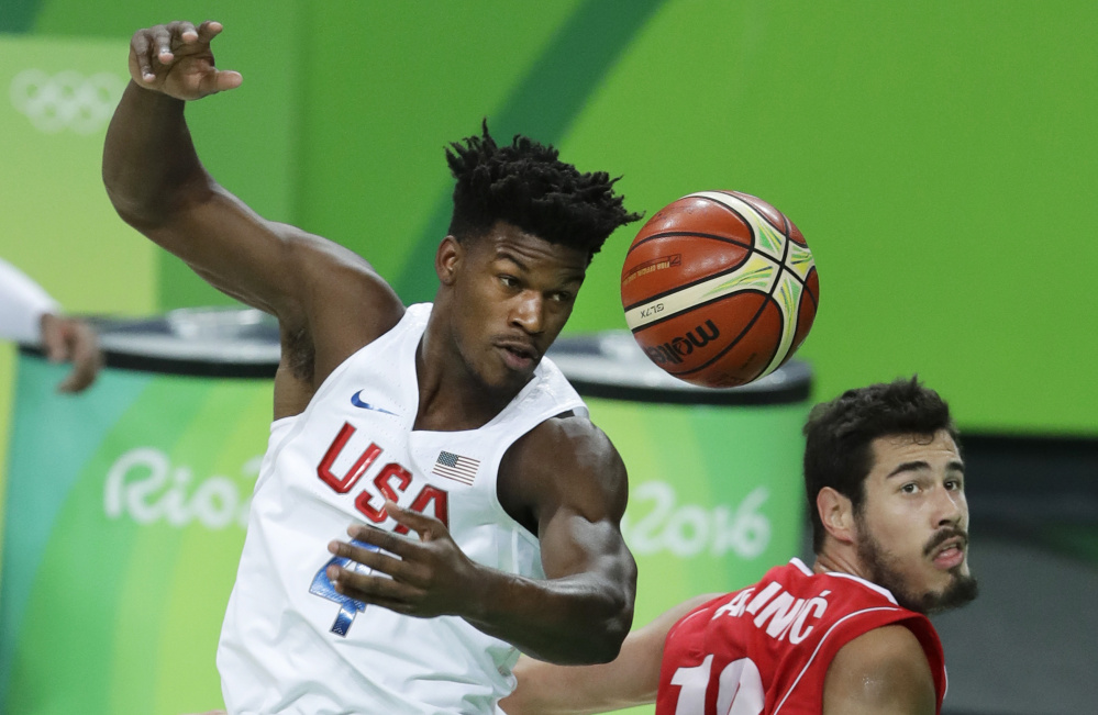 Jimmy Butler, left, of the United States fights for a rebound with Serbia's Nikola Kalinic during the Americans' 94-91 win in Olympic play at Rio de Janeiro. The U.S. has won 49 straight international tournament games.