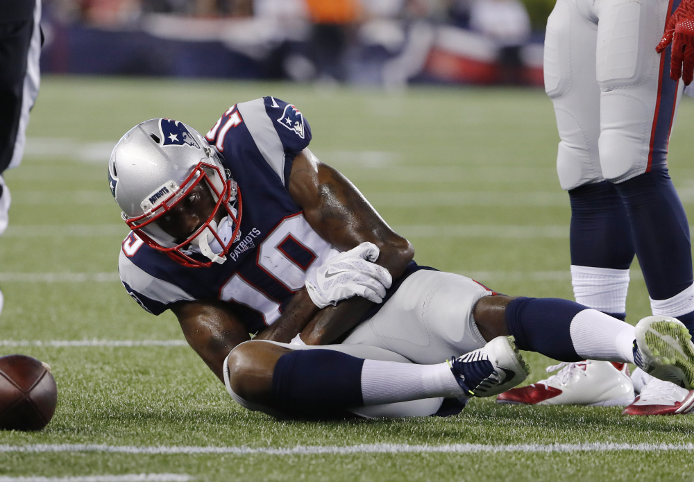 New England wide receiver Malcolm Mitchell holds his left arm after landing on it following a catch in Thursday's preseason game against New Orleans. Mitchell will reportedly miss four weeks with a dislocated elbow.