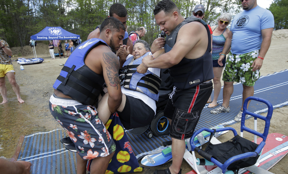 Raquel Ardin of North Hartland, Vt., is helped onto a water ski by volunteers during a rehabilitation clinic. Afterward, she told the volunteers, "You made my day. You made my life!"
