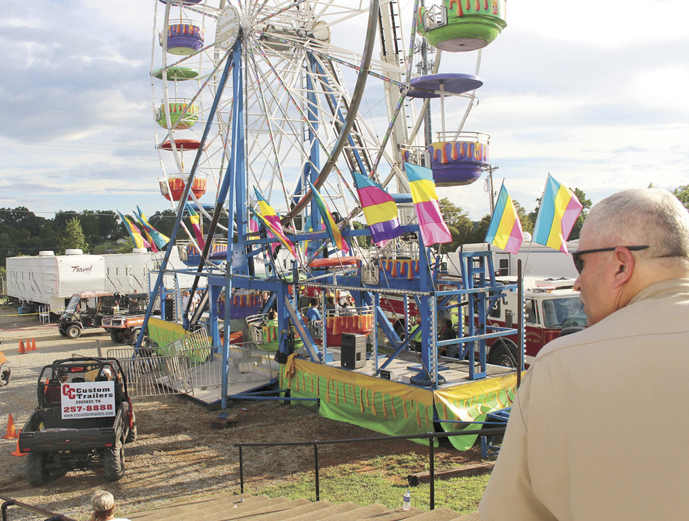 Baileyton, Tenn., police Officer Kenneth Bitner watches as the area is cordoned off after three girls fell from the Ferris wheel at a county fair in Greenville, Tenn. Police say one of the girls suffered a traumatic head injury and remains hospitalized in serious condition.