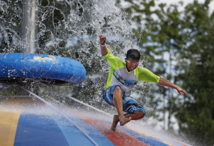 J.J. Camacho, 9, of New York City enjoys the Aquasaucer slide during a gathering of Fresh Air Fund kids and families at Aquaboggan Water Park in Saco on Sunday.