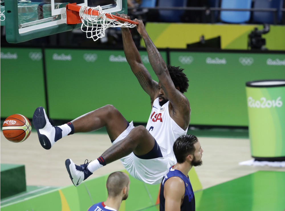 United States' DeAndre Jordan hangs on the rim as he scores against France during Sunday's game at the 2016 Summer Olympics in Rio de Janeiro.