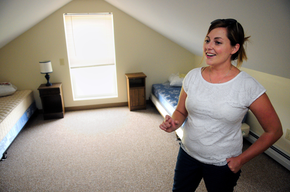 Elaina George, 32, of Sidney, leads a tour of the Hallowell Oxford House several days after it opened as a place for recovering drug addicts to live.