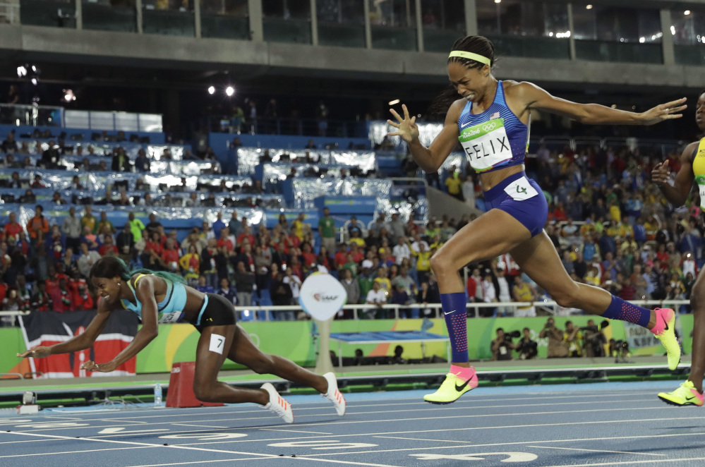 Bahamas' Shaunae Miller falls over the finish line to win gold ahead of United States' Allyson Felix, right, in the women's 400-meter final Monday night in Rio de Janeiro.