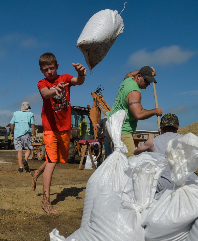 A child piles sandbags to stop rising floodwaters in Lake Arthur, La., on Wednesday. Most people in the area lack flood insurance and many are living amid mud and the threat of mold.