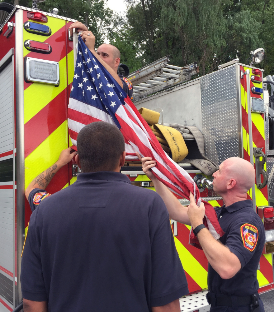 Firefighters remove the banners Tuesday in the Arlington Fire District of Poughkeepsie, N.Y.