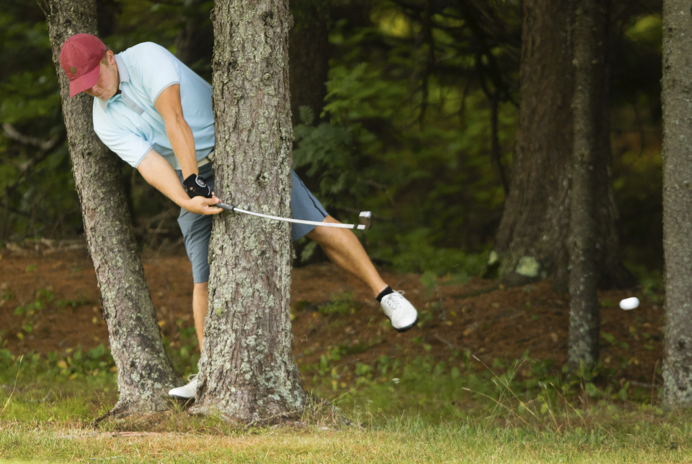 Matt Hutchins of Falmouth hits a shot from between two trees on the 13th hole during the finals of the Maine State Golf Association Match Play Championship on Thursday at Brunswick Golf Club. Hutchins halved the hole against Will Kannegieser and went on to a 1-up victory.