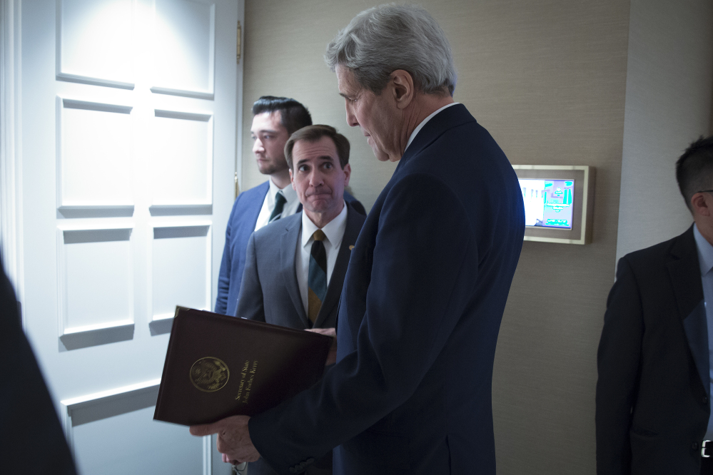 Secretary of State John Kerry speaks to senior adviser John Kirby last year in Vienna. Kirby says negotiations over the U.S. returning Iranian money from a decades-old account was conducted separately from talks that resulted in the release of Americans from Iran.