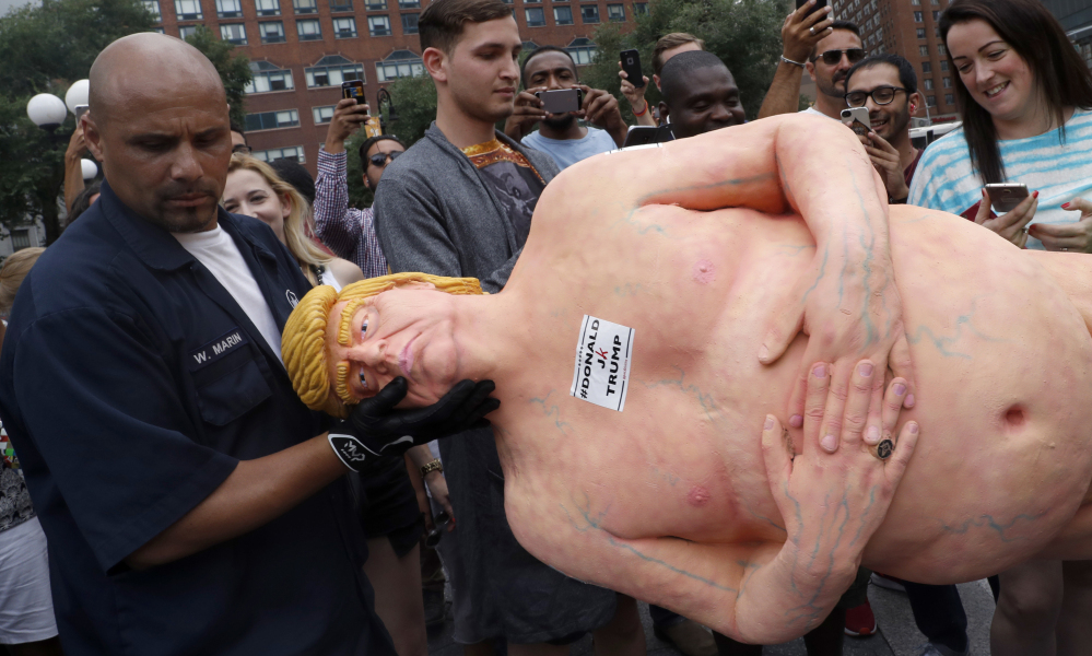 A statue of a naked Donald Trump is removed Thursday from New York's Union Square. Similar statues also appeared in San Francisco, Los Angeles, Seattle and Cleveland.