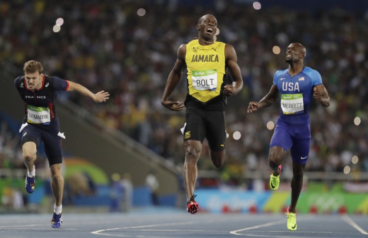 Usain Bolt of Jamaica, center, celebrates after crossing the line to win the gold medal in the men's 200-meter final Thursday in Rio de Janeiro, Brazil.