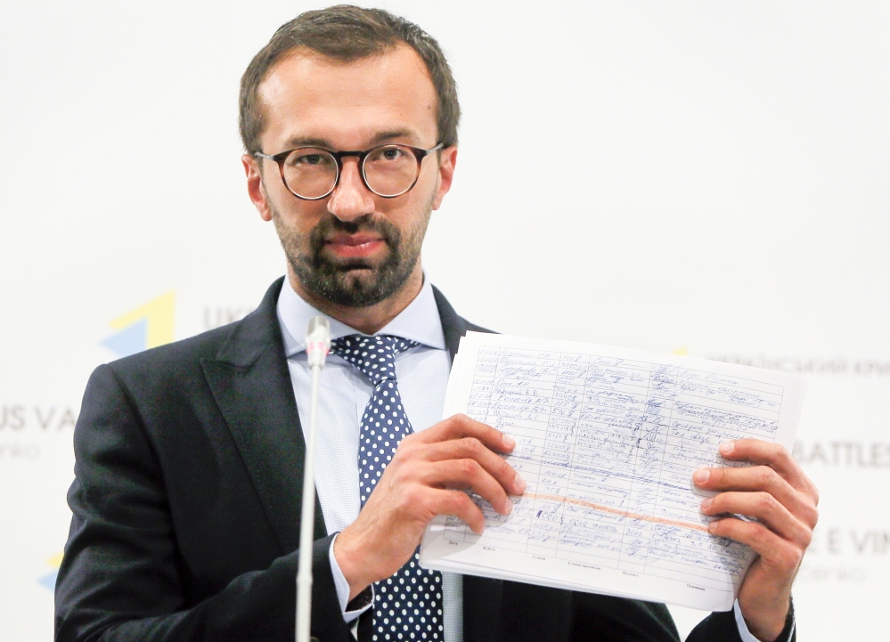 Serhiy Leshchenko, a former investigative journalist turned lawmaker, shows a copy one of the once-secret accounting documents of Ukraine's pro-Kremlin party that were released  and purporting to show payments of $12.7 million earmarked for Donald Trump's campaign chairman Paul Manafort, during a news conference in Kiev, Ukraine, on Friday.