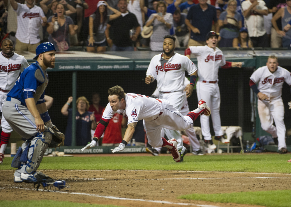 Tyler Naquin, slides into home plate for an inside-the-park home run as Blue Jays' catcher Russell Martin waits for the throw Friday in Cleveland. Naquin's homer gave the Indians a 3-2 win.
