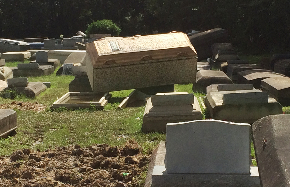 Coffins lie unearthed Thursday in Plainview Cemetery in Denham Springs, La. "You can't even come to see people," one relative said. "You don't know where they're at."