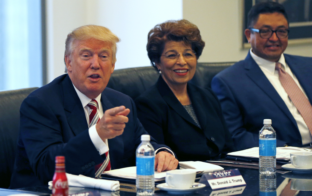 Republican presidential candidate Donald Trump holds a Hispanic advisory meeting in New York on Saturday. With him are Jovita Carranza, former Small Business Administration deputy administrator, and Joseph Guzman, president of the American Society of Hispanic Economists.