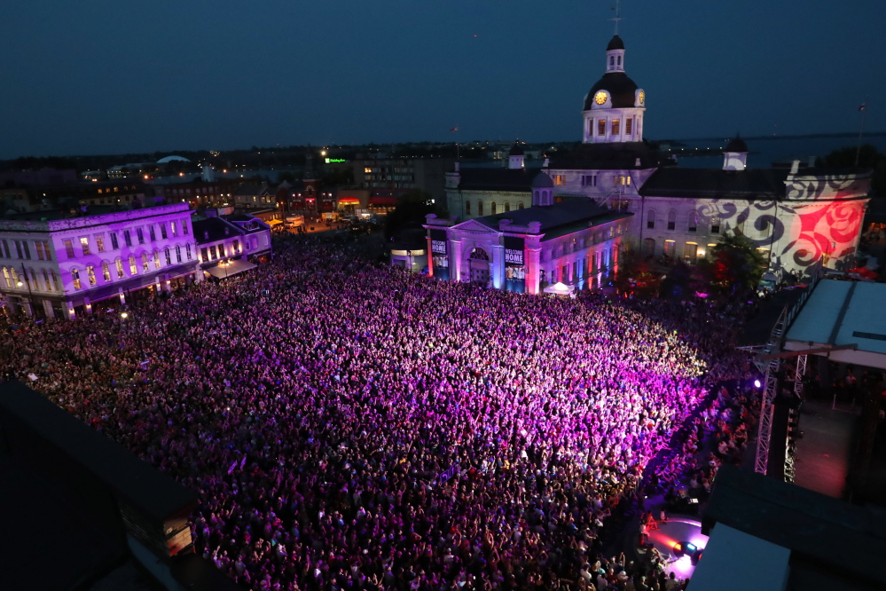 People who could not get a ticket gather to listen to the Tragically Hip in downtown Kingston, Ontario, on Saturday. The Tragically Hip mixed fan favorites, newer songs and some politics during the final show of their "Man Machine Poem" tour.