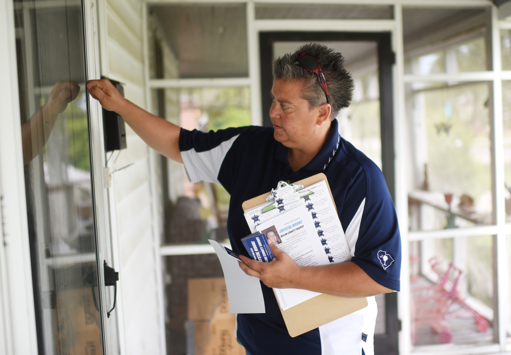 Crystal Moore knocks on a door as she campaigns door-to-door, in Latta, S.C. She has set her sights on becoming the state's first elected female and openly gay sheriff.