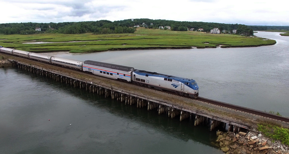 Amtrak's dome car, with the red, white and blue markings, is first in the line of passenger cars as the Downeaster travels through the Scarborough Marsh. The dome car hasn't been used on the Downeaster line before.