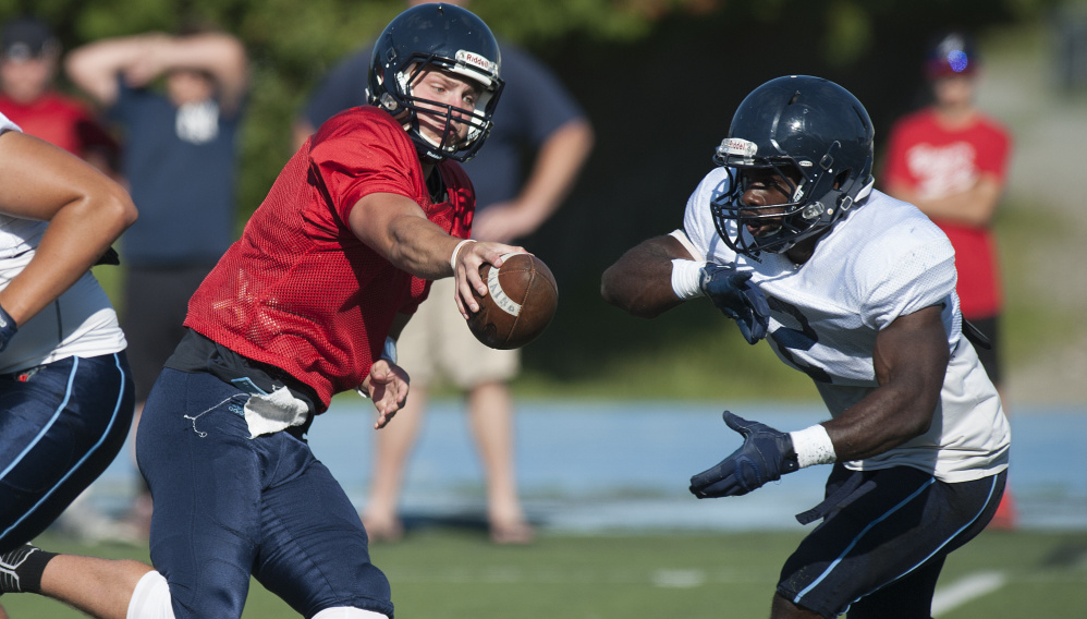 Maine quarterback Dan Collins fakes a handoff to Nigel Beckford during the Black Bears' final scrimmage Sunday in Orono. Collins threw three touchdowns.