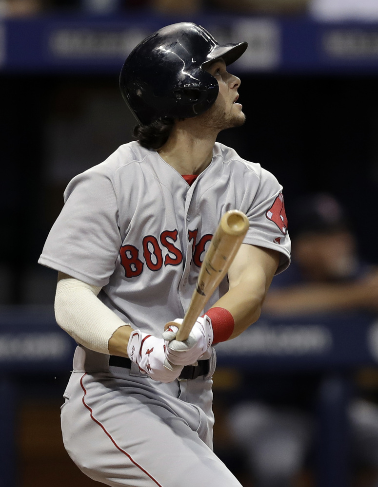 Boston's Andrew Benintendi hits a sacrifice fly off Tampa Bay pitcher Blake Snell, driving in Sandy Leon in the fourth inning of Monday night's win in St. Petersburg, Fla. In the eighth inning, Benintendi made a spectacular catch to rob Steven Souza Jr. of a two-run home run.