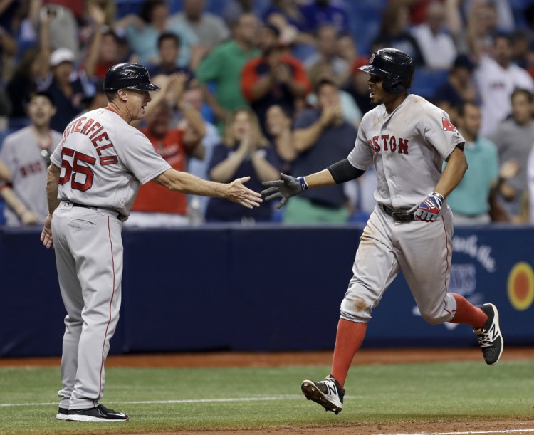 Xander Bogaerts shakes hands with third base coach Brian Butterfield after hitting a two-run home run in the ninth inning Monday night.