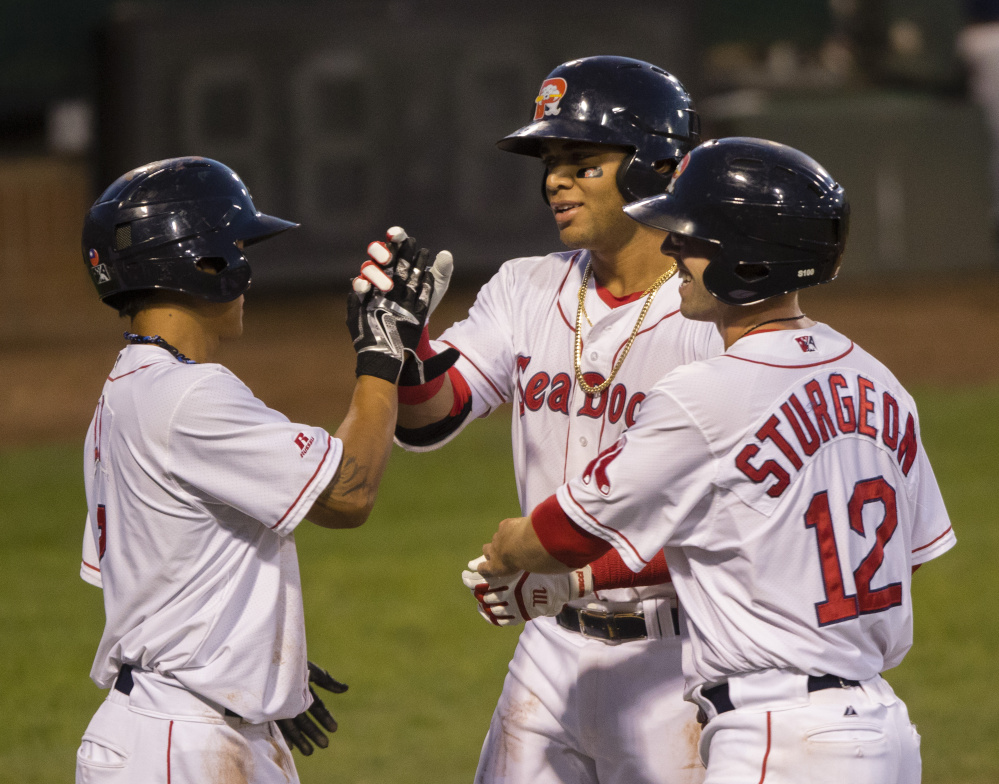 PORTLAND, ME - AUGUST 23: Portland Sea Dogs batter Yoan Moncada is congratulated by teammates Tzu-Wei Lin (L) and Cole Sturgeon after he knocked them in with a 2nd inning home run against the New Hampshire Fisher Cats in AA baseball action at Hadlock Field in Portland on August 23, 2016 . (Photo by Carl D. Walsh/Staff Photographer)