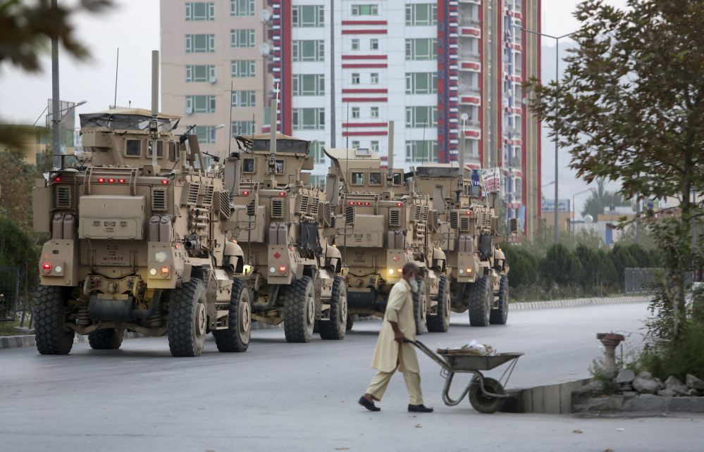 Military vehicles guard the American University of Afghanistan in Kabul on Thursday, a day after an attack there left 13 dead.