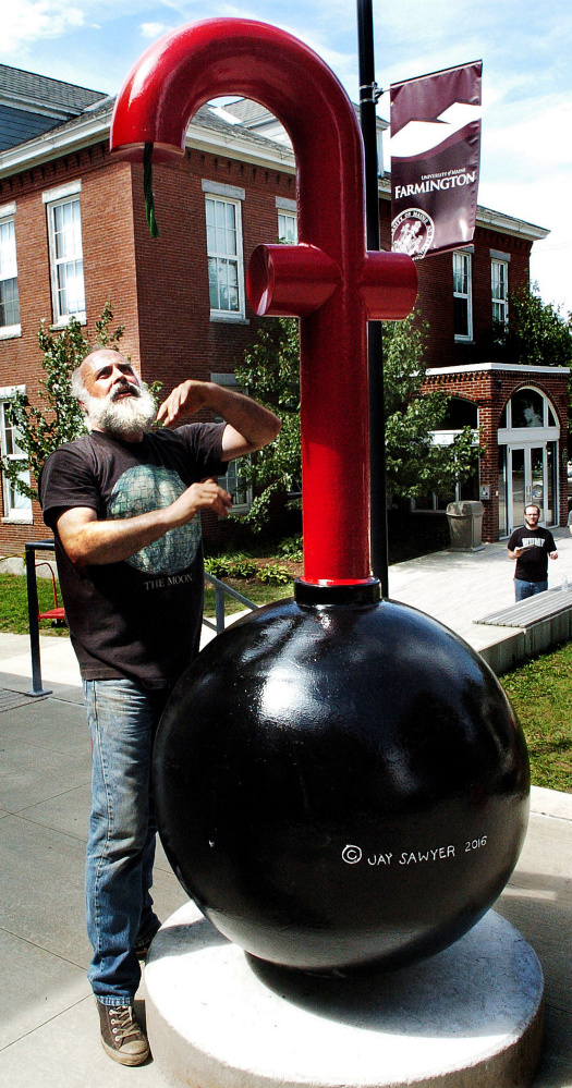 Jay Sawyer finishes setting up his "F Bomb" sculpture Thursday as part of an exhibit at the Emery Community Art Center at the University of Maine in Farmington.