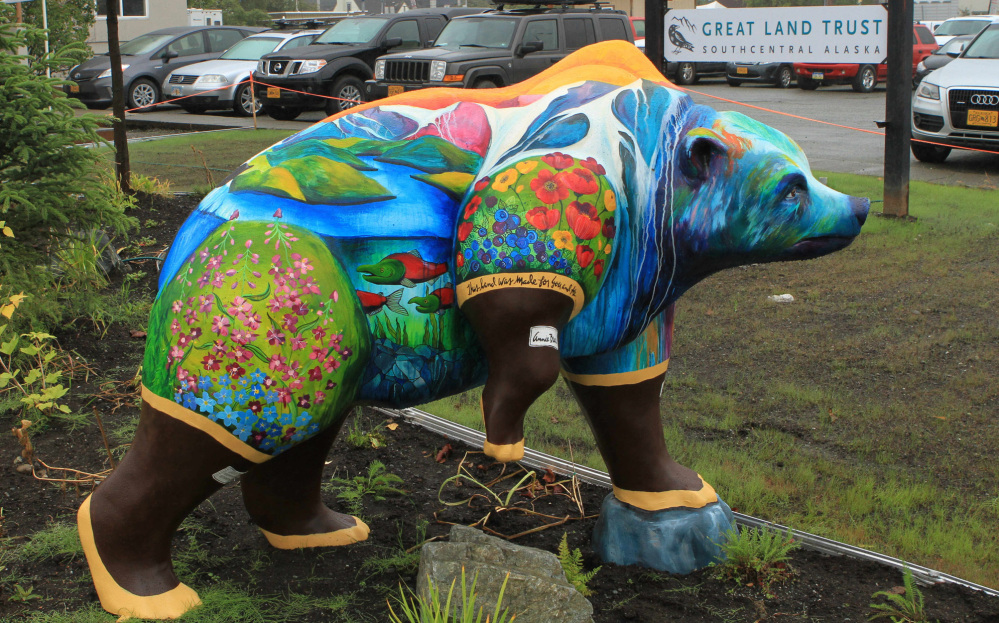 Nature scenes and rubber boots adorn this faux grizzly in front of offices of Great Land Trust.