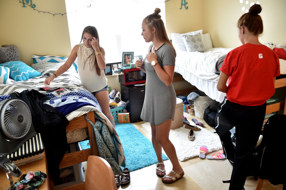 Mackenzie Carlow, left, settles into her drom room Friday with roommates Taylor Peno, center, and Ashlyn Parker at Thomas College in Waterville. There are 320 new students at the school this year.