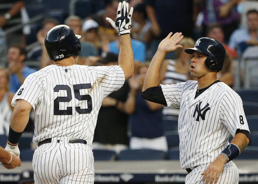 Gary Sanchez, right, greets Yankees teammate Mark Teixeira after scoring on Teixeira's first-inning, two-run homer against Baltimore on Friday. Sanchez also went deep for host New York.