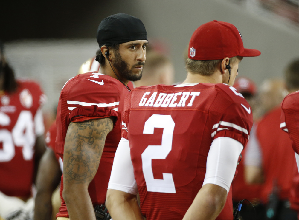 San Francisco 49ers quarterbacks Colin Kaepernick, left, and Blaine Gabbert stand on the sideline during an NFL preseason football game against Green on Friday in Santa Clara, Calif. Kaepernick refused to stand for the national anthem before the game as a protest against violence targeting minorities.