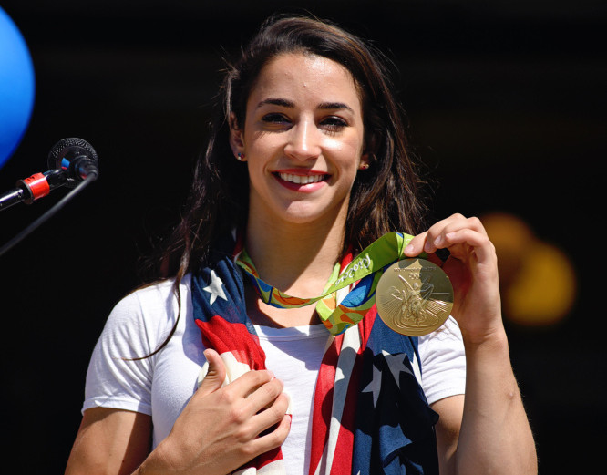 Aly Raisman shows off her gold medal at the Rally for Aly in Needham, Mass., on Saturday.