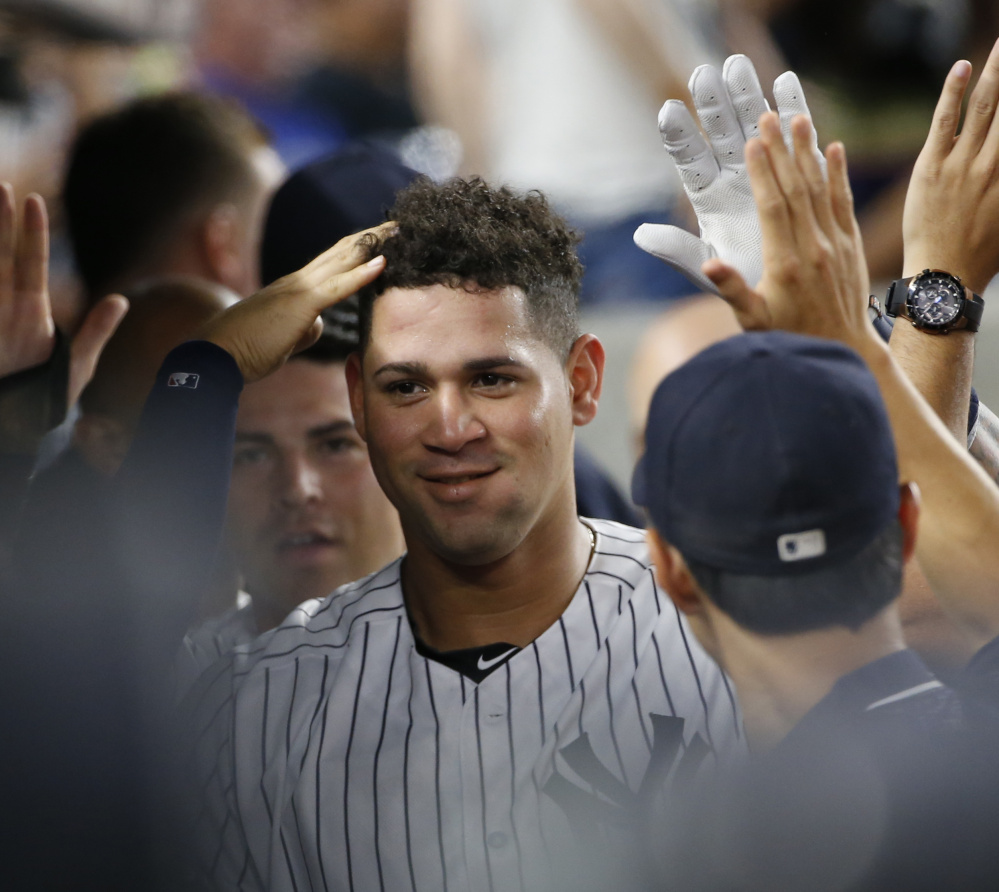 Gary Sanchez of the New York Yankees is welcomed by teammates Saturday after setting a major league record for fastest to 11 career homers – 23 games.