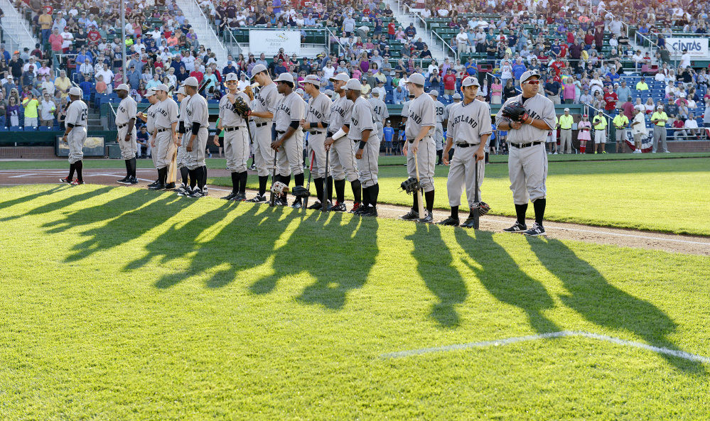 Portland Sea Dogs players, wearing throwback uniforms from the Portland Eskimos of the 1920s, line up along the first-base line on "Field of Dreams" night at Hadlock Field.