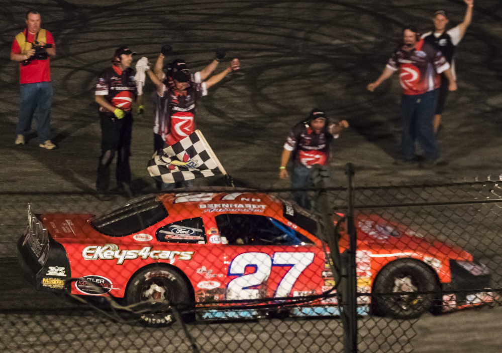 Ben McCanna/Staff Photographer
Wayne Helliwell Jr.'s pit crew celebrates as Helliwell waves the checkered flag during his victory lap after winning the Oxford 250 on Sunday night at Oxford Plains Speedway.