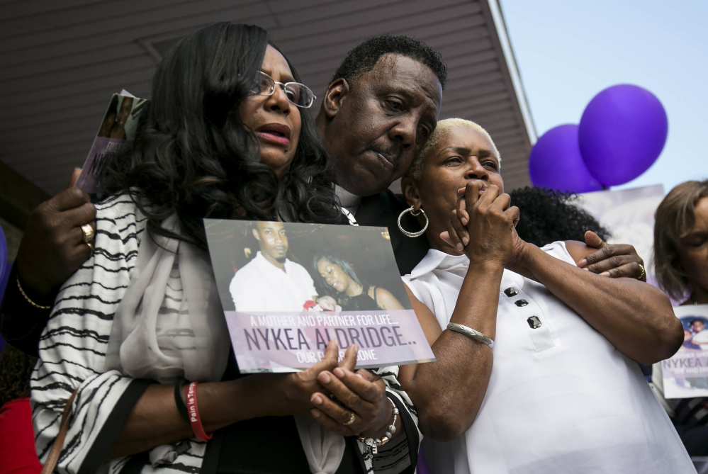 Family members and supporters hug Diann Aldridge, left, during a vigil for her daughter Nykea Aldridge on Sunday. There were 65 homicides in July alone in Chicago.