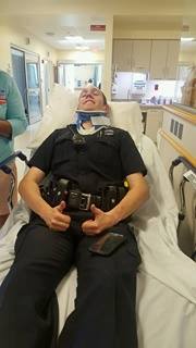 Officer Lucas Shirland wears a neck brace in a hospital bed after his cruiser was hit by a drunk driver. Topsham Police Facebook photo